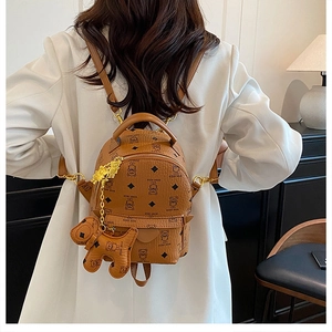 Detail of a brown faux leather mini backpack with teddy bear prints and gold zippers