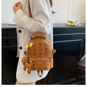 Detailed side view of a brown mini backpack with bear patterns and golden hardware