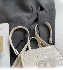 Detail of cream sequin backpack with 3D bow design and smooth long shoulder straps