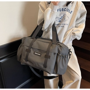 Détail du grand sac de voyage gris avec poignées renforcées et bandoulière réglable