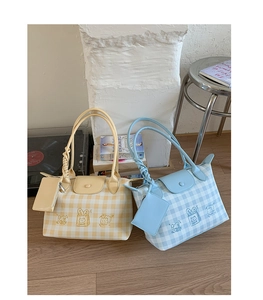 Detail view of large plaid tote bags with cute cartoon prints and detachable mini pouches