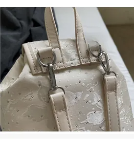 Detailed close-up of cream jacquard fabric backpack with premium silver metal hardware
