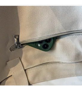 Detail of canvas tote bag featuring a practical side zipper pocket for smartphone storage
