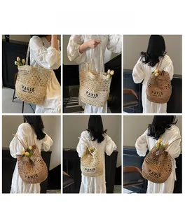 Vistas múltiples de un bolso tote de paja tejida beige con inscripción de París