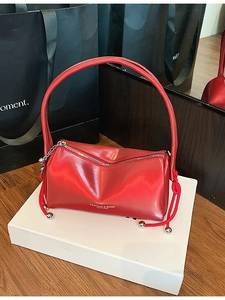Chic red leather pillow handbag with drawstring side details on a white gift box