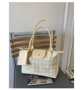 Close-up of yellow checkered tote bag featuring cute cartoon cat embroidery and mini pouch