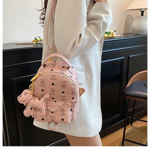 Pink mini backpack detail featuring teddy bear patterns and a matching dog charm accessory