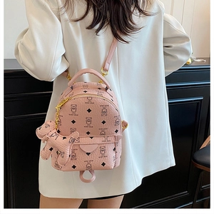 Detailed macro view of pink mini backpack featuring teddy bear prints and dog charm