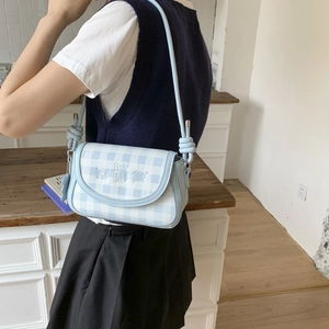 Detail of blue and white plaid crossbody bag with cute cartoon embroidery and slim strap