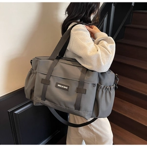 Sac de sport gris foncé imperméable avec logo WEILAI-BAG porté à l'épaule de dos