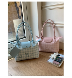 Detail of cute canvas tote bags in blue and pink with cartoon bread and heart patterns
