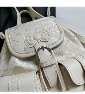Detail of cream denim backpack with pearl jacquard texture and 3D bow decoration