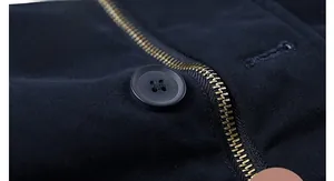 Close-up of durable matte black buttons and metal zipper teeth on navy twill jacket