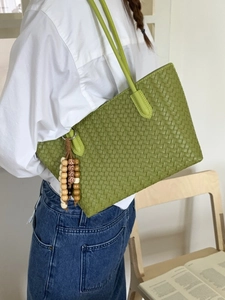 Large grass green woven tote bag with wooden bead tassel and Intrecciato texture