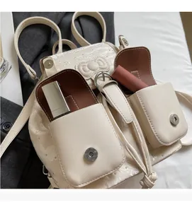 Detail of cream denim backpack showing magnetic pockets with a glitter finish and cute bow