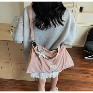 Lifestyle view of large pink canvas tote bag with star charm worn by a model