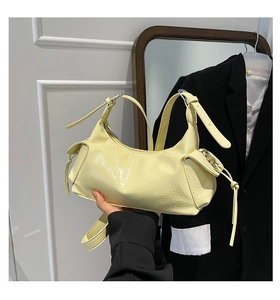 Dettaglio della borsa a tracolla in vernice giallo chiaro con tasche laterali a coulisse
