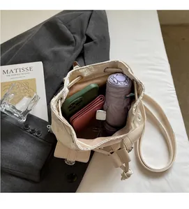 Top view of cream denim backpack showing spacious interior with phone and wallet