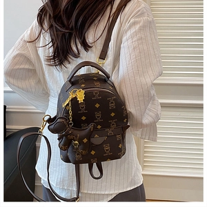 Detail of dark brown mini backpack with bear monogram pattern and gold hardware