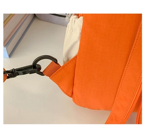 Detail of orange ripstop nylon fabric with black plastic swivel hook and woven strap