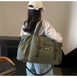 Sac de voyage vert olive porté par un mannequin montrant la grande capacité en nylon