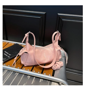 Dettaglio della borsa a mezzaluna rosa con pelle plissettata e lacci laterali