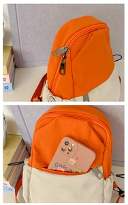 Detail view of orange and beige nylon backpack front pocket showing smartphone storage capacity