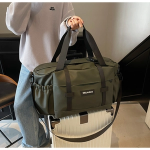 Détail du sac de voyage vert militaire montrant la texture nylon et le logo de marque