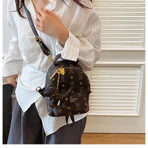 Mini coffee brown PU leather backpack with bear print and cute dog charm shown on a model