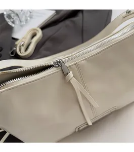 Close-up of smooth silver zipper and stitching on a minimalist beige pillow bag