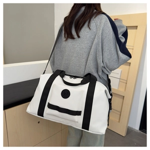 Spacious white travel duffel bag with black straps being carried in a modern interior