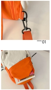 Detail of black metal swivel hook and orange webbing on the two-tone nylon backpack