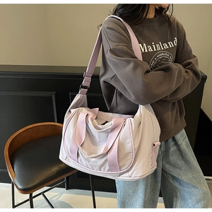 Détail du sac de voyage en nylon lavande avec poignées renforcées et logo gaufré