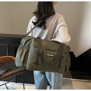 Sac de voyage vert olive avec logo WEILAI-BAG porté par un mannequin dans un décor lifestyle