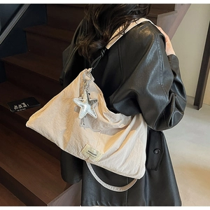 Detail of beige canvas tote bag with star charm and swagger label on fabric