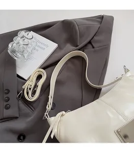 Detail of cream white tote bag on grey blazer with detachable shoulder straps