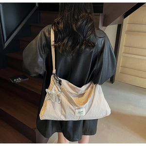 Rear view of a beige nylon tote bag with Swagger label and shiny star pendant