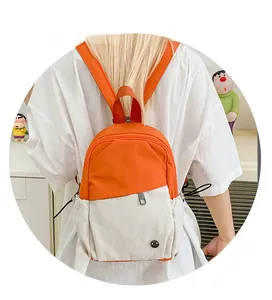 Close-up of contrast color mini backpack in orange and beige with side drawstring detail