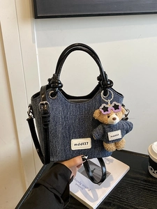 Sac seau en denim avec poignées en cuir noir et breloque ours en décor lifestyle