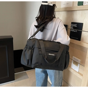 Détail du grand sac de voyage noir avec nylon haute densité et poche latérale à cordon