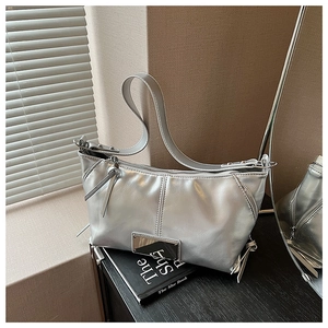 Close-up of metallic silver tote bag with polished zipper and metal logo plate