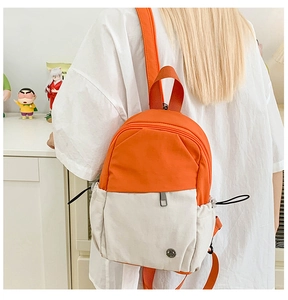 Detail of mini canvas backpack in orange and white contrast with drawstring side pockets