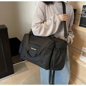 Détail du sac de voyage noir étanche avec poche latérale élastique et bandoulière réglable