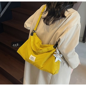 Detail of yellow nylon tote bag with Swagger label and silver star charm accessory