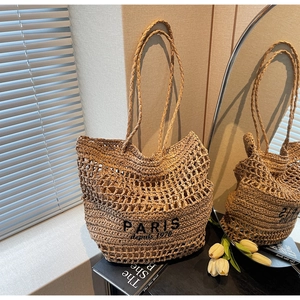 Detalle de bolso tote de paja tejida con texto negro Paris 1970 de estilo francés