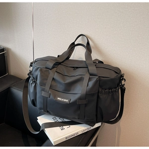 Gros plan du sac de voyage noir montrant le tissu imperméable et les poches de rangement
