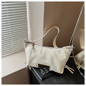 Detail of cream white leather underarm bag with metal buckle and soft PU texture