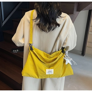 Macro shot of bright yellow canvas tote bag with swagger label and silver star pendant
