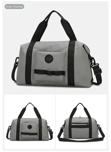 Detail view of grey waterproof travel bag featuring black webbing handles and logo