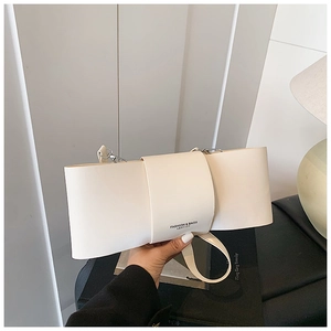 Close-up of creamy white leather bow bag with silver hardware and fashion text detail